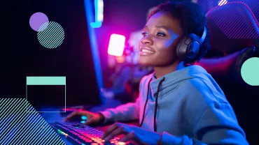 Persona jugando en una computadora con auriculares, luces de colores.