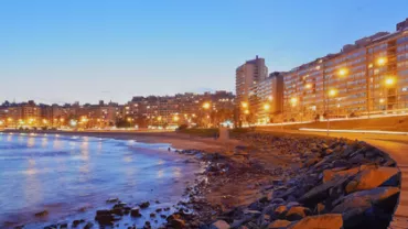 Vista nocturna de la costa con luces y edificios en Montevideo.