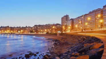 Vista nocturna de la costa con luces y edificios en Montevideo.