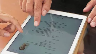 Dos personas revisando un documento en una tableta.