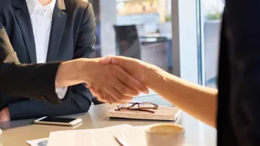 Personas estrechando manos en una reunión de negocios.