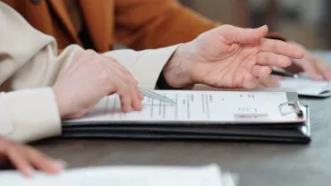 Personas revisando documentos en una mesa.