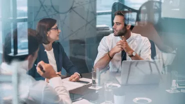 Reunión de negocios con personas conversando en una oficina.