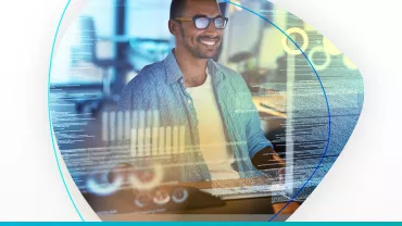 Hombre sonriendo frente a la computadora con gráficos digitales.