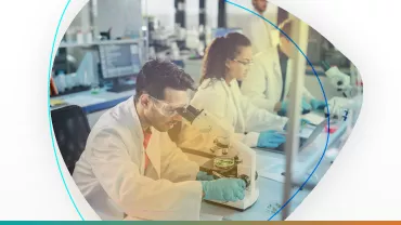 Científicos trabajando en un laboratorio con microscopios.