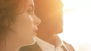 Dos personas iluminadas por el sol, mirando hacia la derecha.