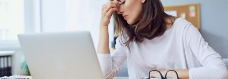 mujer cansada frente a computadora
