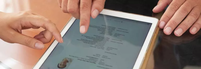 Dos personas revisando un documento en una tableta.