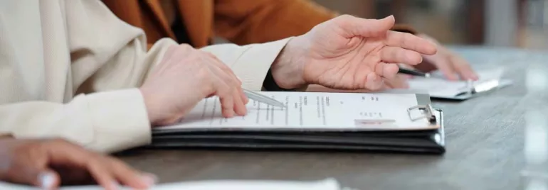 Personas revisando documentos en una mesa.