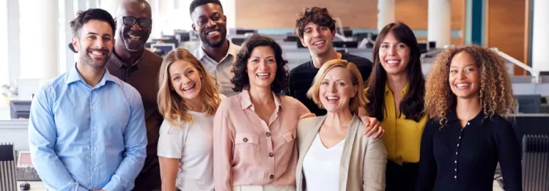 Grupo de personas sonrientes en una oficina.