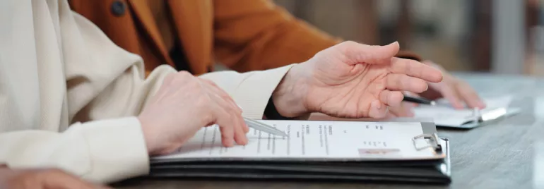 Personas revisando documentos en una mesa.