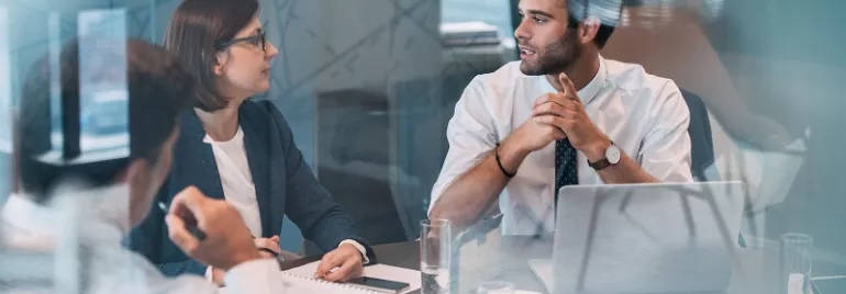 Reunión de negocios con personas conversando en una oficina.