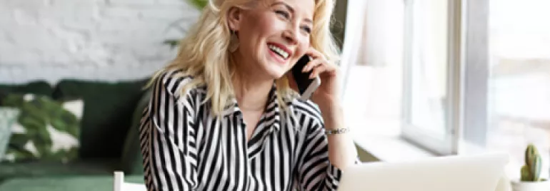 mujer hablando por celular y sonriendo