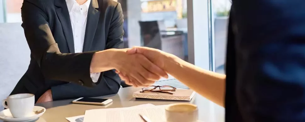 Personas estrechando manos en una reunión de negocios.