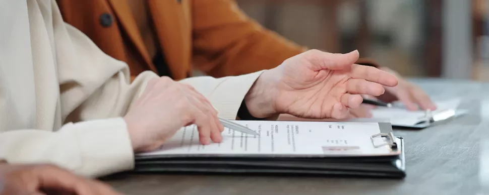 Personas revisando documentos en una mesa.