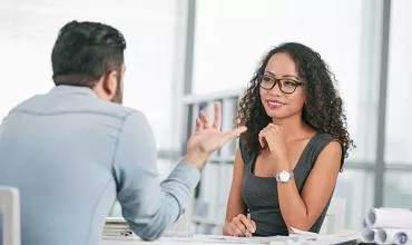 Dos personas conversando en una oficina.