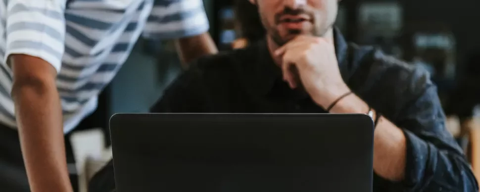 Personas trabajando juntas frente a una laptop.