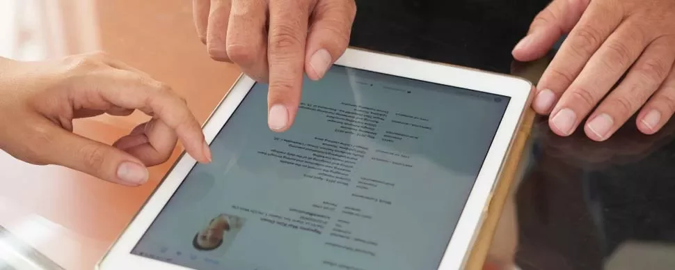 Dos personas revisando un documento en una tableta.
