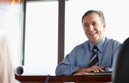 Hombre sonriendo en una reunión de oficina.